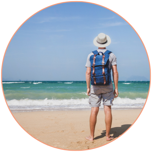 Voyageur avec sac à dos face à la mer sur une plage