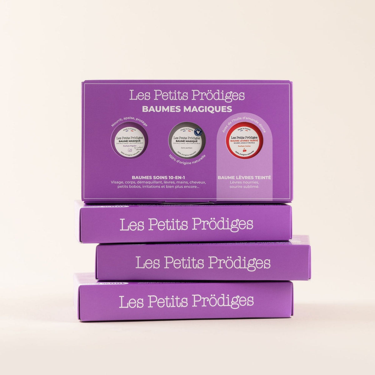 Coffrets Magiques Les Petits Prödiges violets empilés, coffret cadeau de trois baumes naturels pour le visage, le corps et les lèvres.