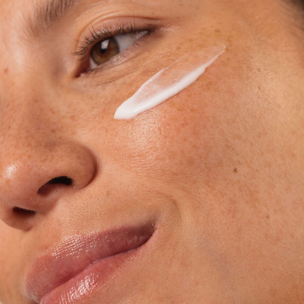 Femme souriante avec une touche de crème blanche sur la pommette