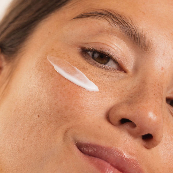 Femme souriante avec une touche de crème blanche sur la pommette