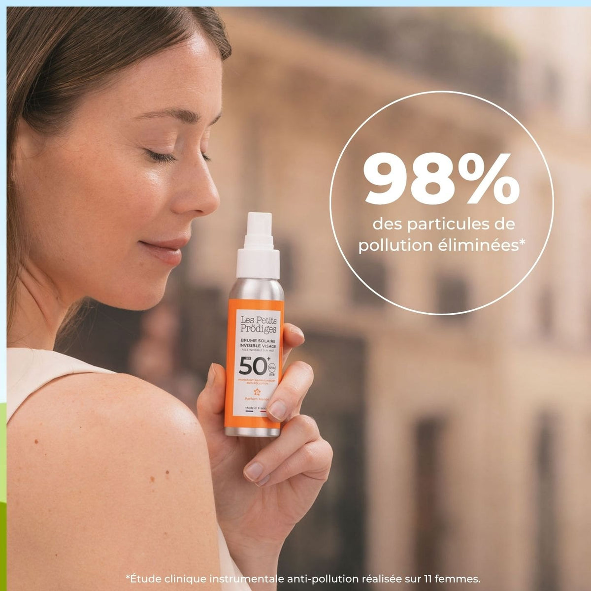 Femme tenant la Brume Solaire Invisible SPF 50+ en ville, 98 % des particules de pollution éliminées