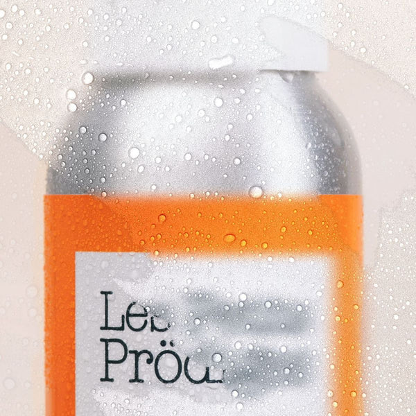Flacon de Brume Solaire Invisible couvert de gouttelettes d'eau