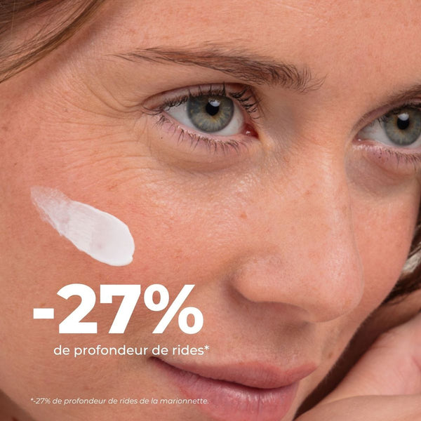 Femme avec une touche de crème sur la pommette, -27 % de profondeur de rides