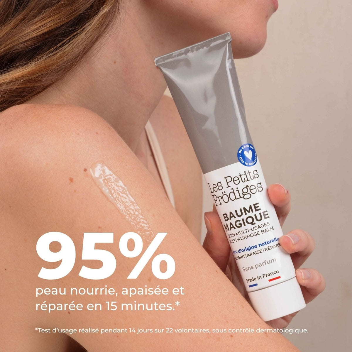 Femme appliquant le Baume Magique en tube sur l'épaule, 95 % peau nourrie, apaisée et réparée en 15 minutes