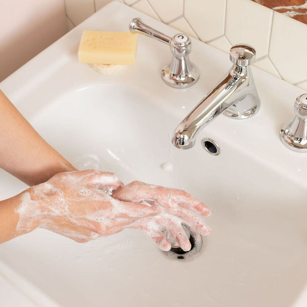 Mains se lavant avec le Savon Peau Douce au-dessus d'un lavabo