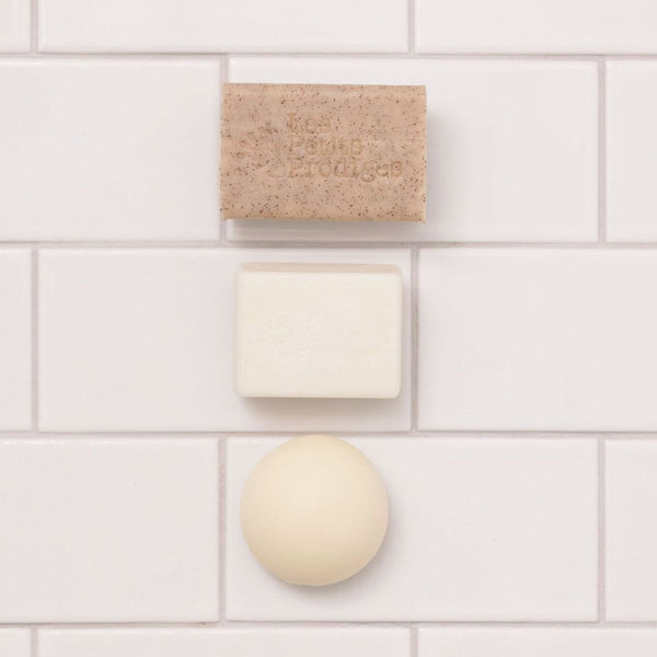 Savon, Shampoing Solide Amande et boule de soin fixés sur un carrelage blanc