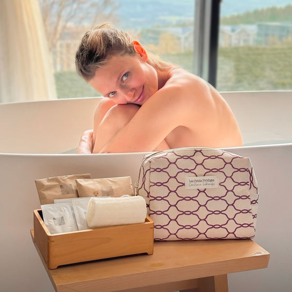 Femme souriante dans un bain avec la trousse d'été Les Petits Prödiges et ses soins