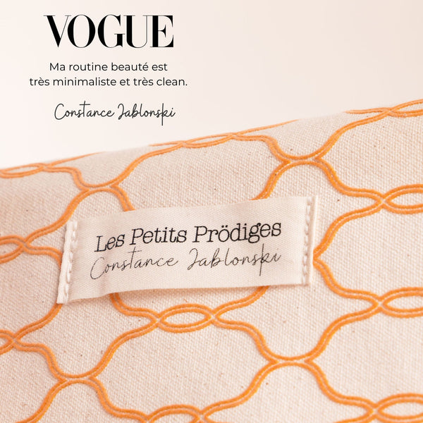 Trousse Constance Jablonski x Les Petits Prödiges, en coton beige brodé orange, avec une citation de Constance Jablonski parue dans Vogue.